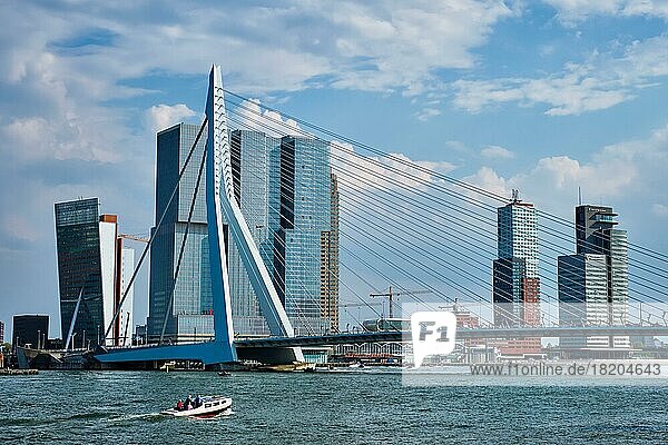 ROTTERDAM  THE NETHERLANDS  MAY 11  2017: View of Rotterdam sityscape with Erasmusbrug bridge over Nieuwe Maas and modern architecture skyscrapers with speed boat passing uner the bridge
