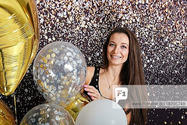 Schöne glückliche Frau zwischen Partyballons