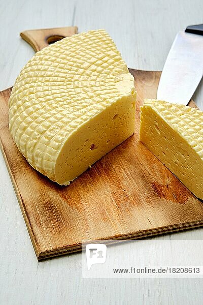 Frischer Adyghe-Käse in Scheiben geschnitten auf einem Holzbrett