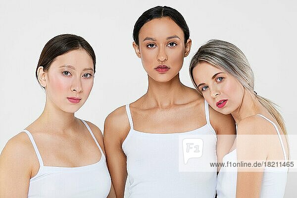 Multi-ethnic beauty concept. Beautiful asian  caucasian and african young women with different types of skin in white panties and shirt