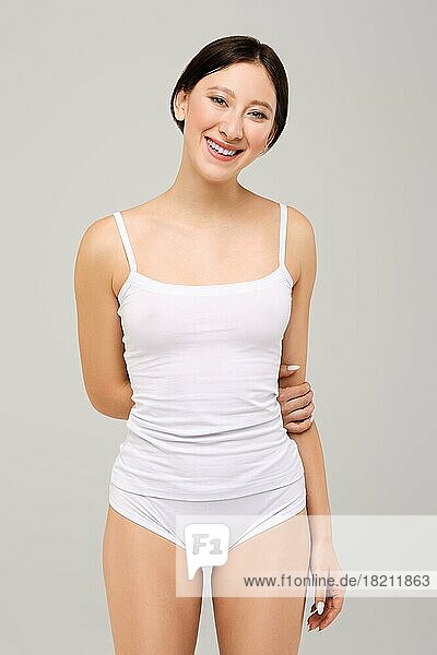 Nettes und glückliches asiatisches Mädchen in weißem T-Shirt und natürlichem Make-up