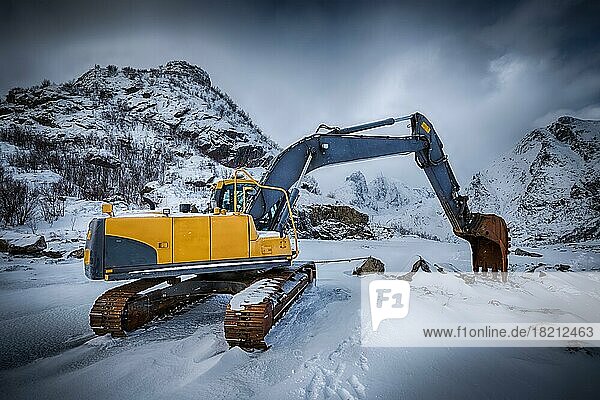 Alter Bagger mit Baggerschaufel im Winter. Straßenbau im Schnee. Lofoten-Inseln  Norwegen. HDR-Bild mit hohem Dynamikbereich