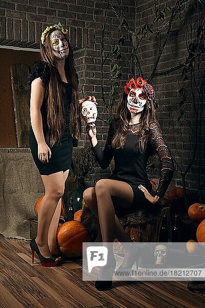 Zwei junge Frauen mit Zuckerschädel-Make-up an Halloween. Gesichtsbemalung Kunst