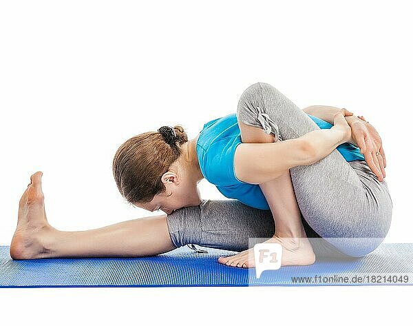 Yoga  junge schöne schlanke Frau Yogalehrer tun Vorwärtsbeugen Sage Twist A Pose (Marichyasana A) asana Übung vor weißem Hintergrund