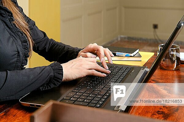Nahaufnahme von weiblichen Fingern beim Tippen auf einem Laptop