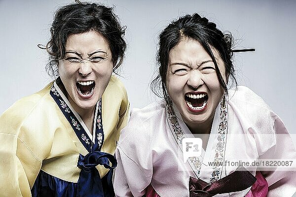 Portrait von zwei Frauen in koreanischer Tracht mit offenem Mund  koreanische Geschwister im Hanbok  Schwestern  Schreien  Korea