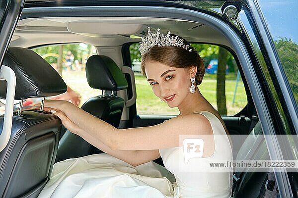 Schöne Braut sitzt auf der Rückbank eines Autos