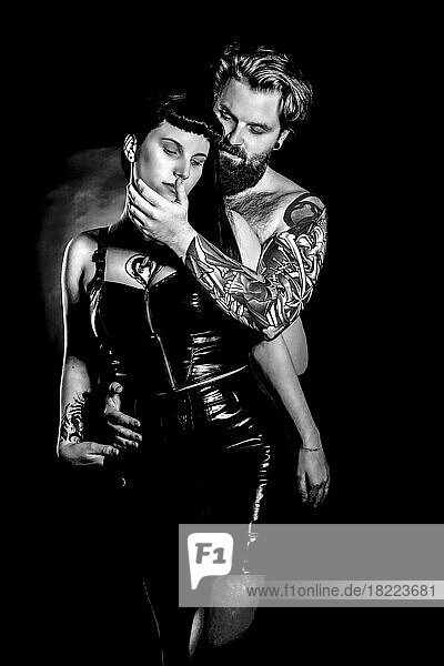 BDSM Paar  Mann mit Tattos und Frau in Lack und Latex Outfit  Schwarz-Weiß-Foto