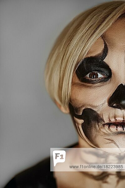 Close-up Porträt der Hälfte weibliches Gesicht mit Zucker Schädel Make-up. Gesichtsmalerei Kunst