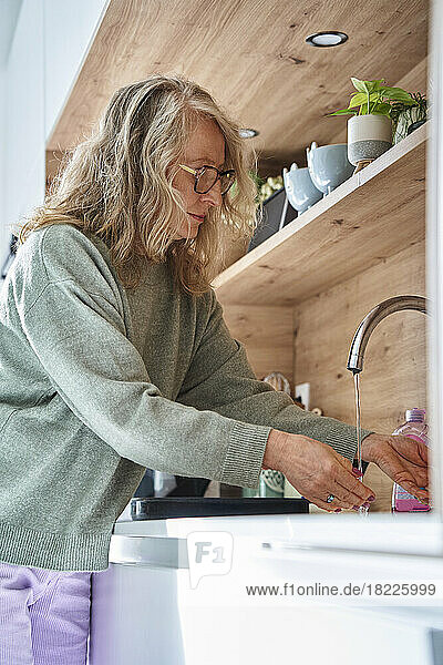 Senior woman doing dishes at kitchen