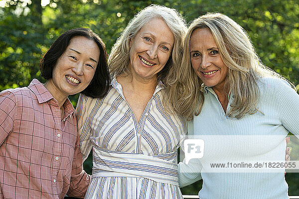 Three senior women posing together for group photo outdoors