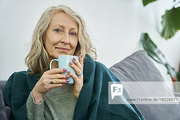 Senior woman having cup of tea while looking at the camera