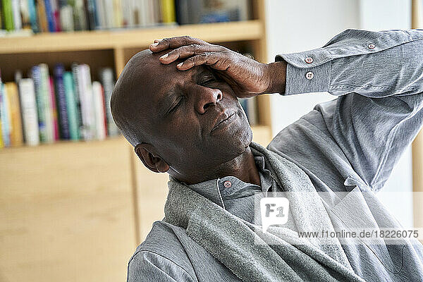 Middle age African-American man holding his head in pain