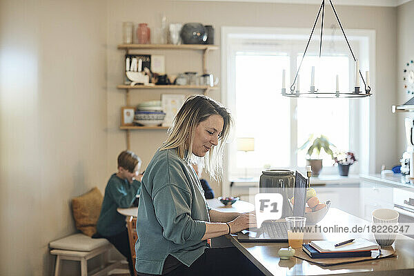 Smiling female freelancer working on laptop at home