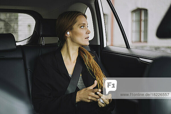 Businesswoman with brown hair sitting in car