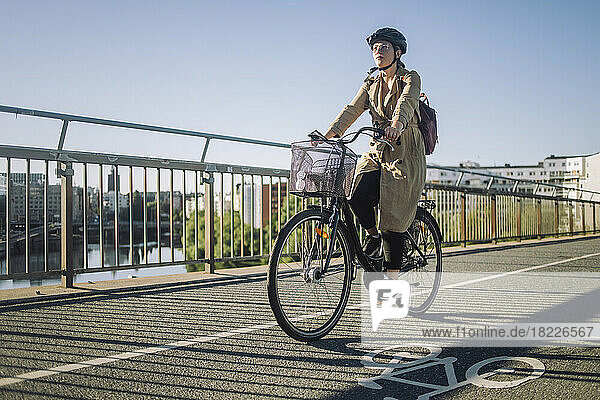 Junge Geschäftsfrau  die auf dem Fahrradweg zur Arbeit fährt