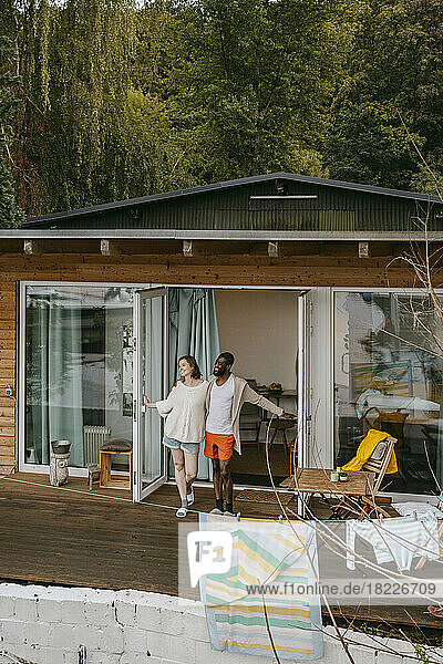Ein gemischtrassiges Paar steht zusammen auf einer Veranda vor der Tür