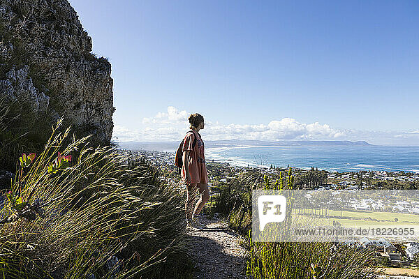 South Africa  Hermanus  Teenage girl (16-17) walking in mountains and looking at sea coast