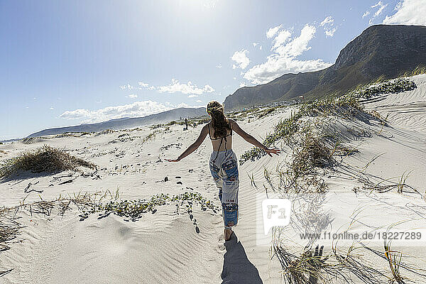 South Africa  Western Cape  Hermanus  Teen girl (16-17) walking on sandy Grotto beach 