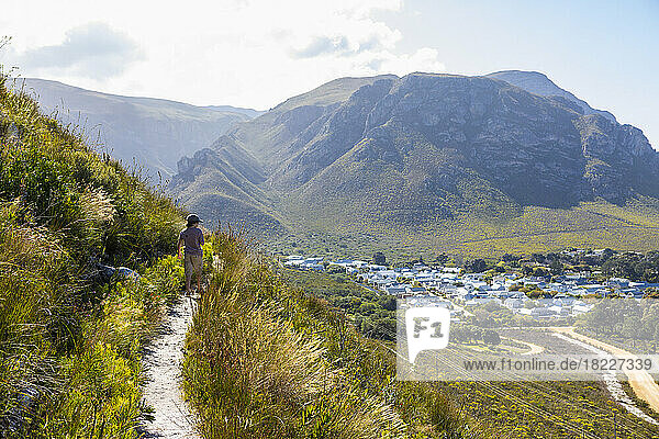 South Africa  Hermanus  Boy (8-9) looking at small town from hiking trail in mountains
