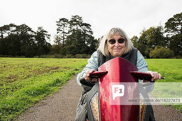 retired disabled woman on a mobility scooter smiling outdoors