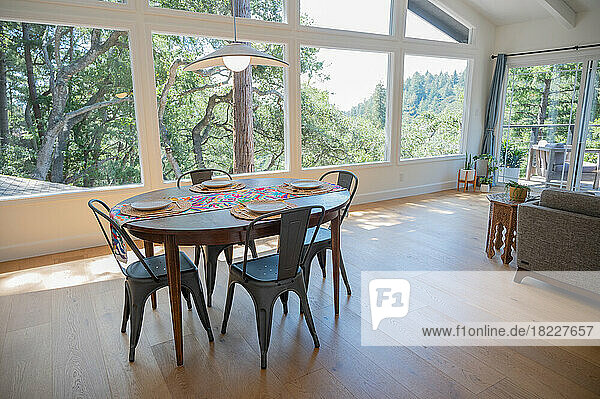 Dining room set for four with view of trees out large windows