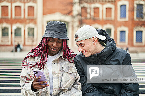 Portrait of a multi-ethnic couple using the phone  in the street