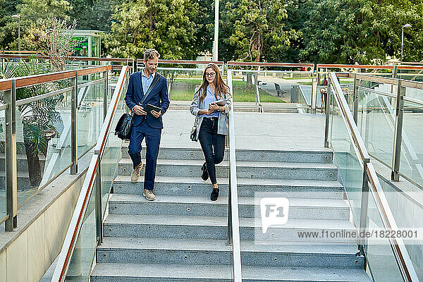 Business colleagues walking down stairs outdoors