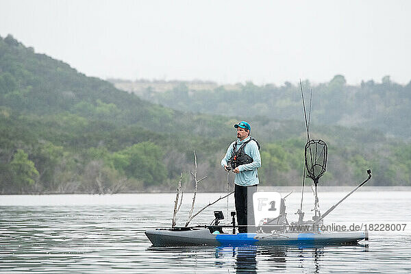 Fishing for bass while standing on kayak on a Texas lake