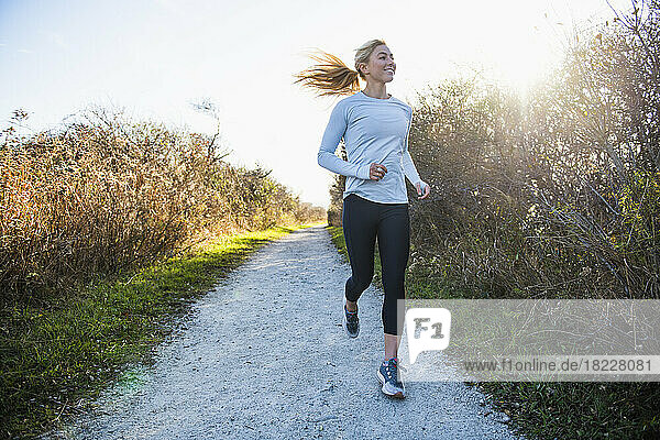 Young woman running on open air coastal trail run workout