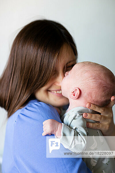 Close-up of happy mother holding baby at home