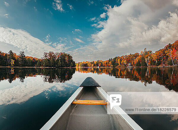 Front of canoe on a calm lake on a sunny autumn day.