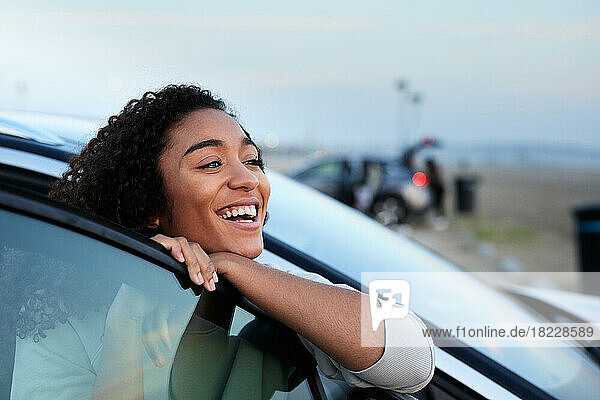 Happy woman leaning on vehicle door
