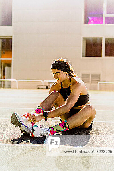 woman tying shoelaces on running track