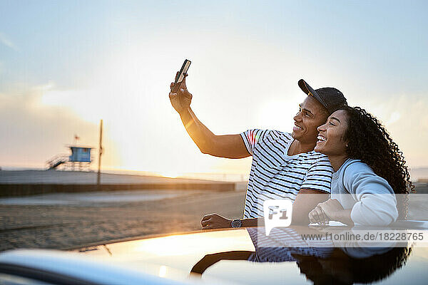 Happy heterosexual couple taking selfie through smart phone
