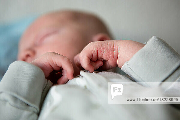 Close up of newborn baby's hands while sleeping in bed at home