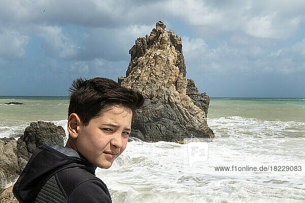 Boy (12-13) by sea and rock  Sicily  Italy