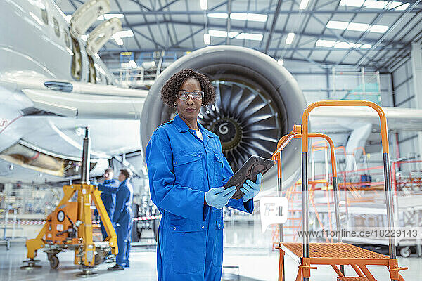 Portrait of female aircraft maintenance engineer in aircraft?hangar