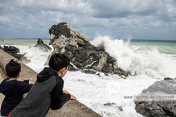 Italy  Sicily  Boys (6-7  10-11) looking at?sea waves crashing