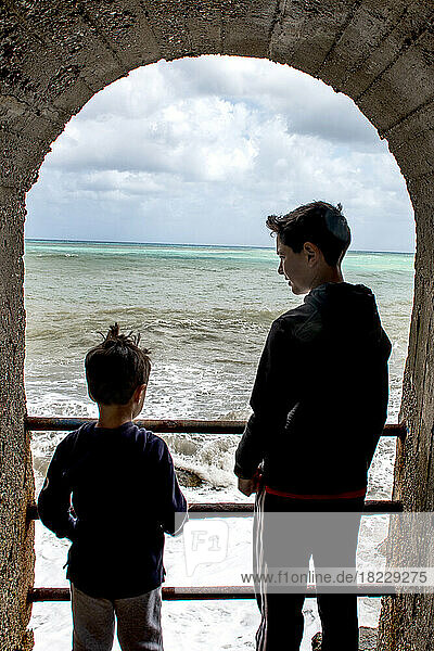 Italy  Sicily  Boys (6-7  10-11) looking at?sea waves