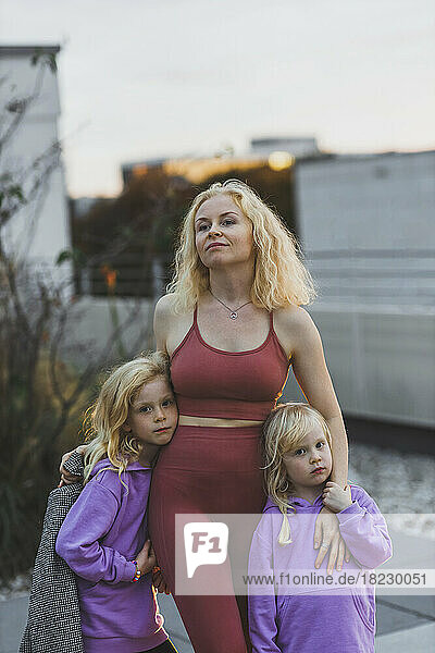 Blond woman with cute daughters on rooftop