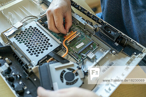 Hands of man repairing computer on table