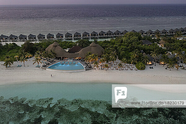 Tourist resort and water bungalows on beach at sunset  Maldives