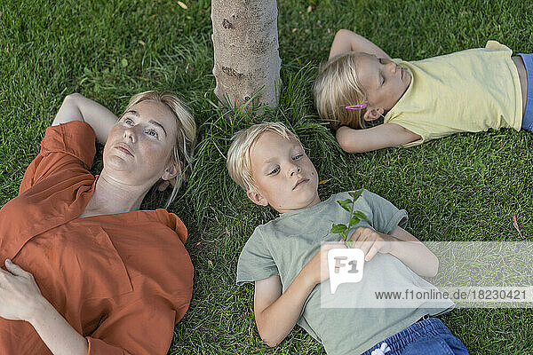 Mother with son and daughter lying down on grass