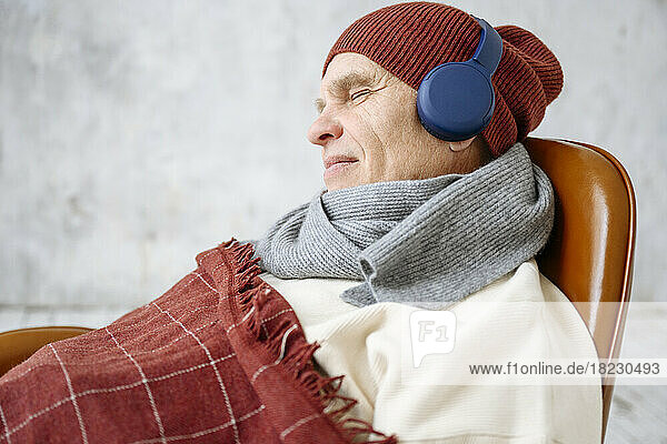 Man with eyes closed listening to music through headphones