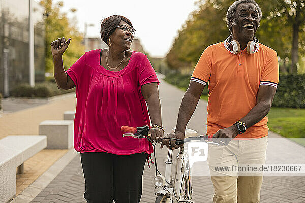 Glückliches Seniorenpaar fährt gemeinsam Fahrrad im Park