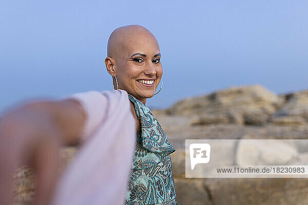 Happy woman with alopecia enjoying at sunset