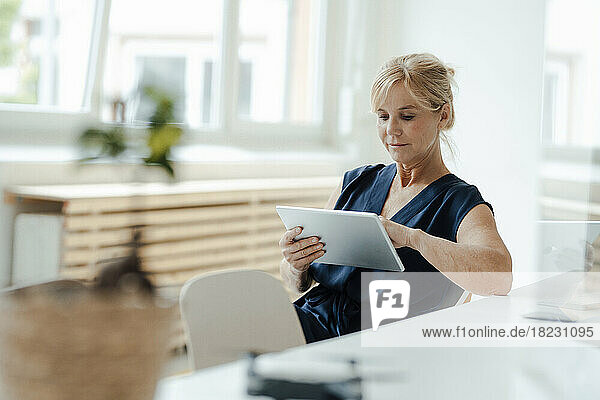 Mature businesswoman using tablet PC at office