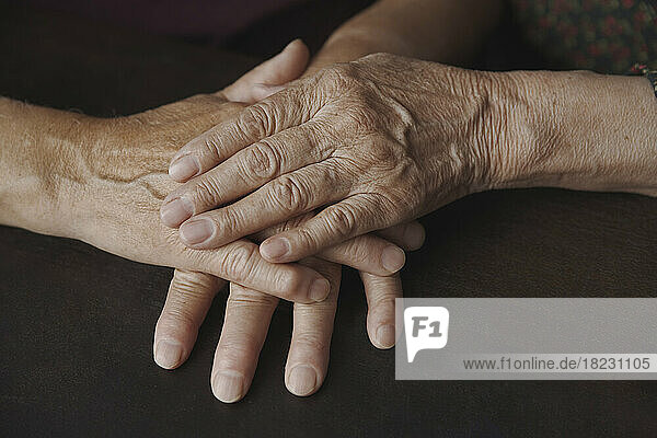 Couple with wrinkled hands on table