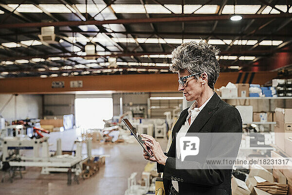 Mature businesswoman using tablet PC at industry